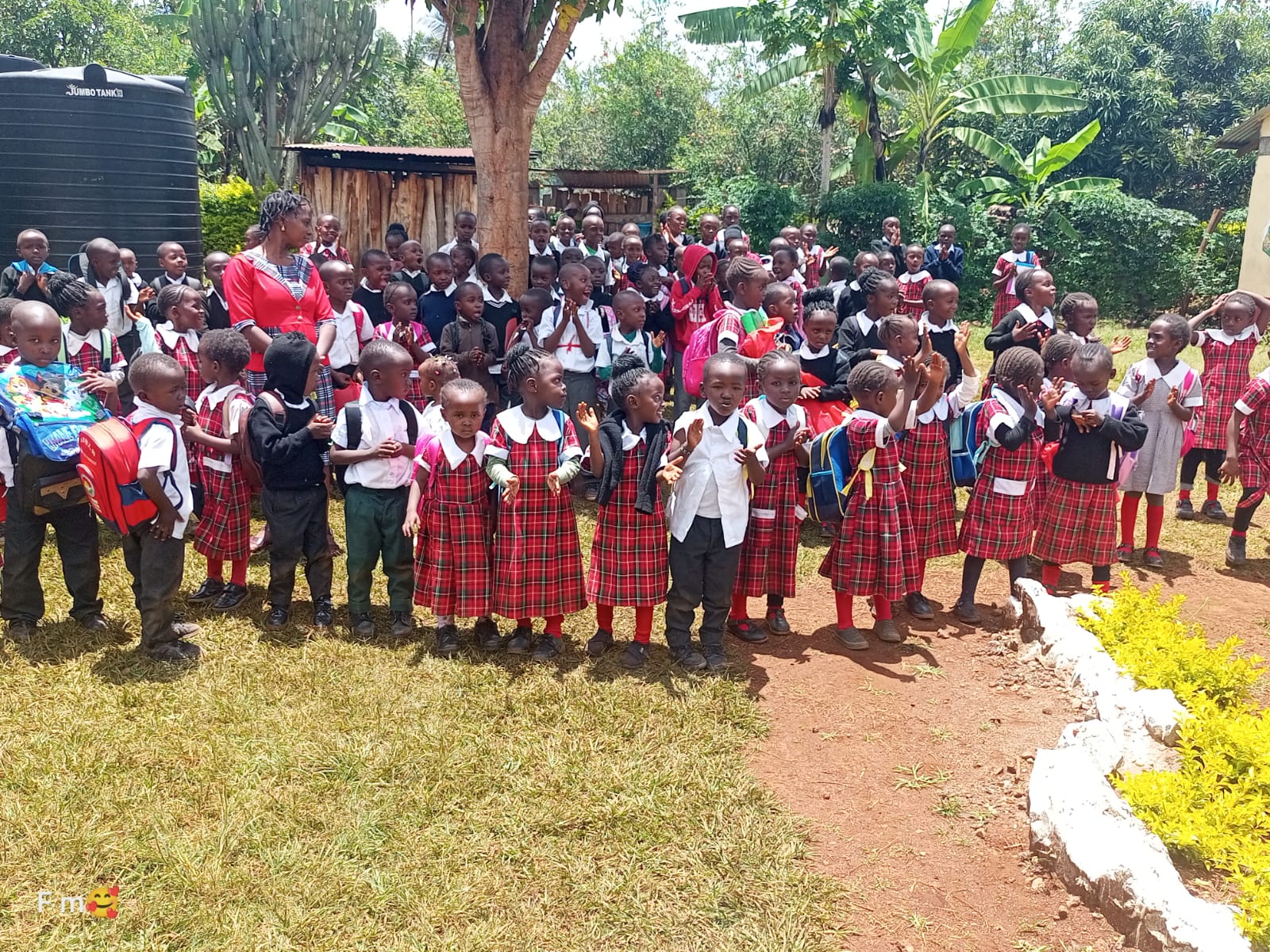 Large group of pupils gathered near the school gate