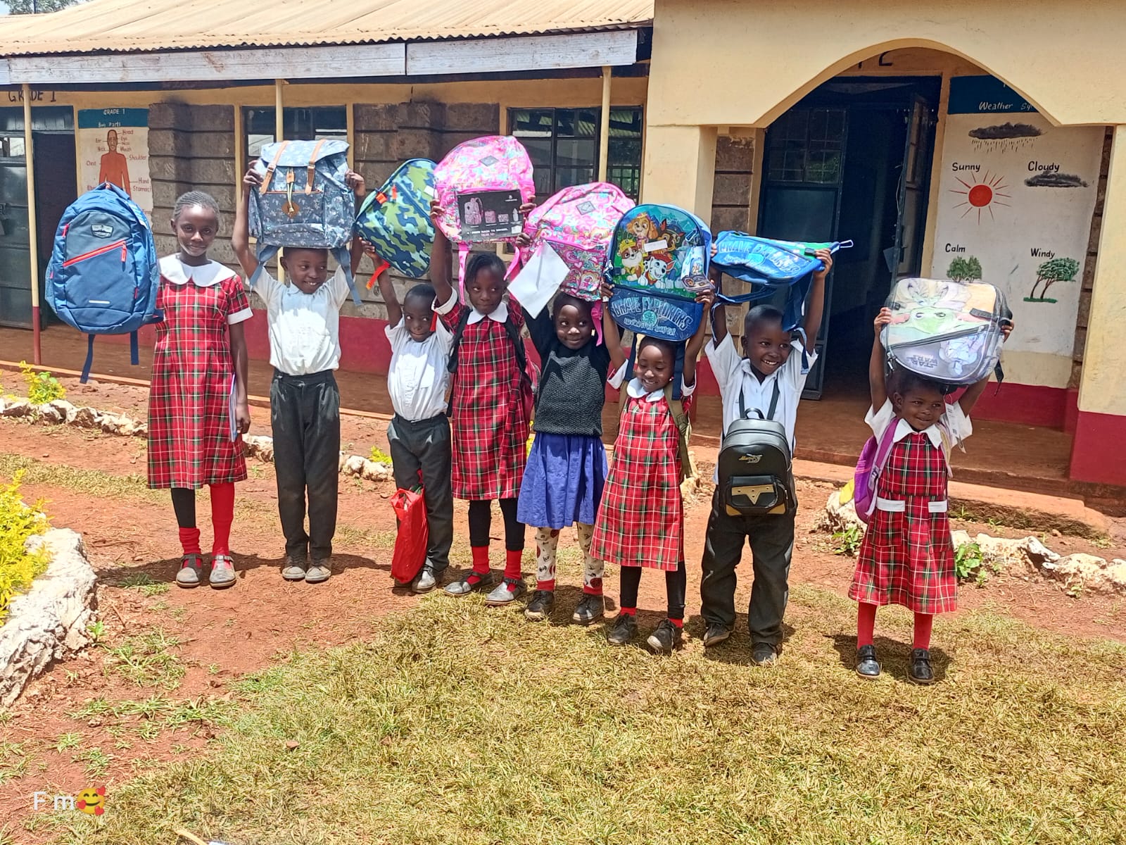 Pupils holding backpacks above their heads